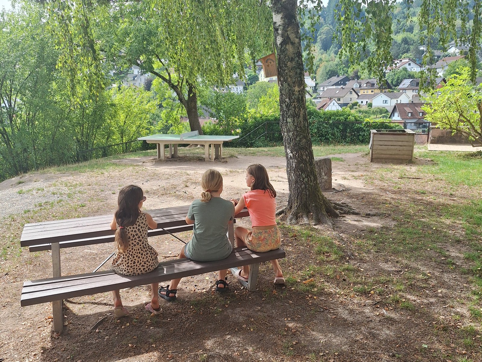 Kinder sitzen gemeinsam auf dem Pausenhof
